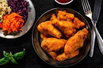     Chicken nuggets with vegetable salad on wooden table 