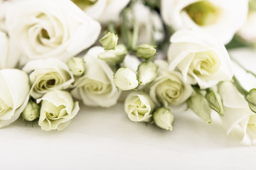 Bouquet of white roses on white wooden table