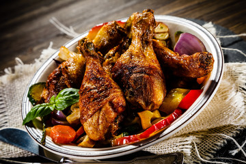 Roast chicken drumsticks on wooden background