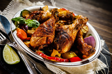 Roast chicken drumsticks on wooden background