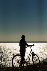 Fototapeta premium Woman relaxing with bike at seaside