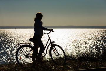 Fototapeta na wymiar Woman relaxing with bike at seaside