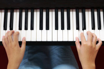 Teenage hands playing piano. Art and music background. Top view.