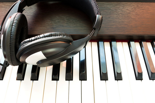 Headphone on piano keyboad. Art and music background.