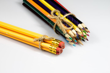 Obraz premium Colored pencil crayons on white isolated ground. School accessories on a white table.
