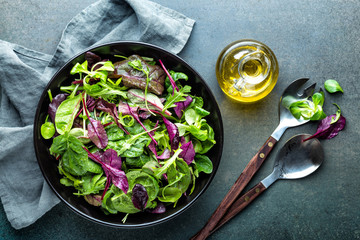 Fresh salad mix of baby spinach, arugula leaves, basil, chard and lambs lettuce. Salad bowl,...