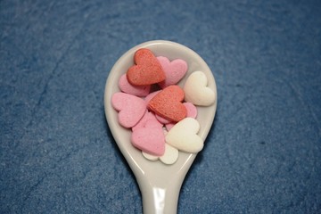 White spoon whit decorative elements. Creative layout of hearts. Selective focus. Food concept. 
