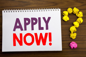 Fototapeta premium Conceptual hand writing caption inspiration showing Apply Now. Business concept for Job Hiring Application written on notepad note paper on the wooden background with question mark.