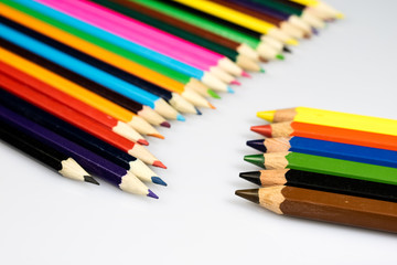 Fototapeta premium Colored pencil crayons on white isolated ground. School accessories on a white table.