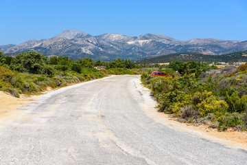 Asphalt road with view of mountains in summer day. Naxos island. Cyclades, Greece