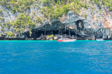 Fototapeta na wymiar Boats in front of the Viking Cave. Ko Phi Phi Leh is well known for its horrible mass tourism