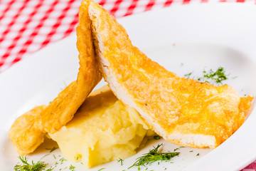 Chicken chops with mashed potatoes and dill on white plate