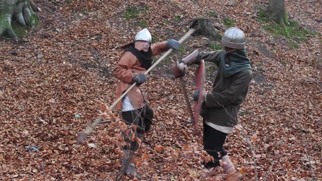 Two warriors Viking are fighting with swords in the forest