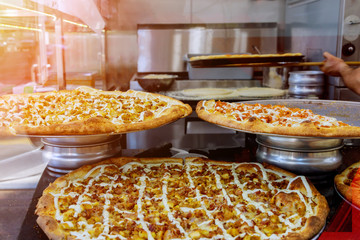 Chef in preparing delicious pizza at kitchen. Italian style pizza on the counter before baking.