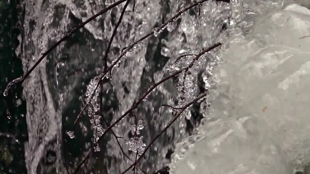 frozen waterfall with ice in a blue and white color in winter. Slow motion
