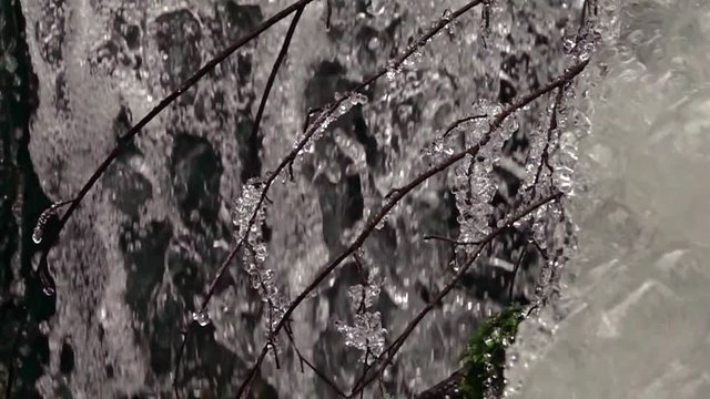 frozen waterfall with ice in a blue and white color in winter. Slow motion
