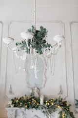 Christmas morning . classic apartments with a white fireplace, decorated fir tree, sofa, large windows and chandelier.