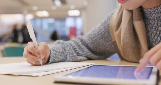 Student study and doing homework with using tablet computer at library