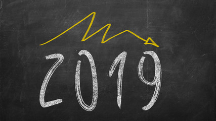 pessimistic year graph drawn on the blackboard. handwritten 2019 year inscription with falling yellow arrow