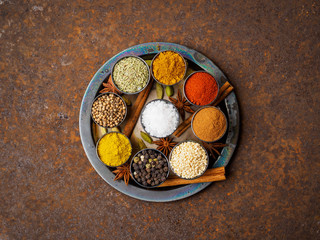 Mix spices on round metal plate - coriander seeds, ground red pepper, salt, black pepper, rosemary,...
