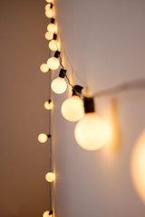 Garland with lamps on the wall in the apartment