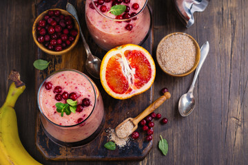 Healthy refreshing pink smoothie with apple, red oranges, cowberry and bran