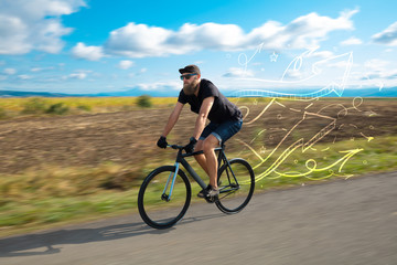 Fototapeta premium Young cyclist in with meadow background