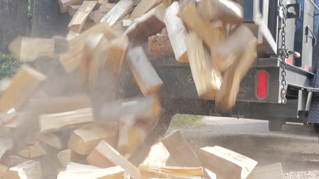 Unloading a trailer full of firewood.