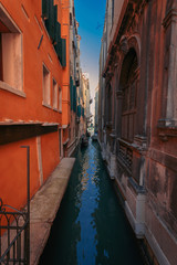 Fototapeta na wymiar Узкий венецианский канал и гондолы с туристами между историческими зданиями. Венеция. Италия.