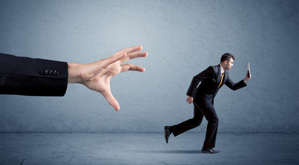 Businessman running from hand