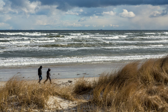 Promenad p&aring; strand vid havet en mulen vinterdag