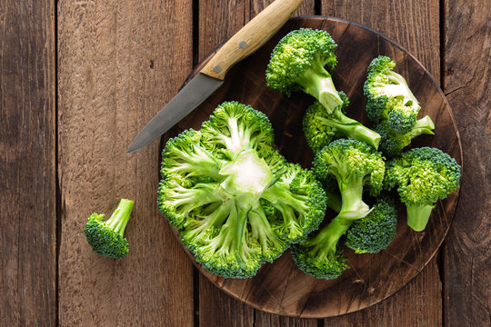 Fresh broccoli on wooden rustic table, top view