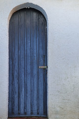 Alte Holztür in blau und alte weiße Fassade