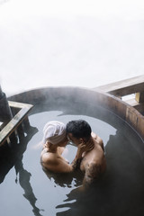 Young couple in hot spring - obrazy, fototapety, plakaty