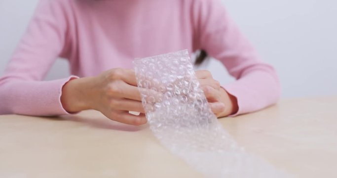 Woman play with bubble wrap to relief stress