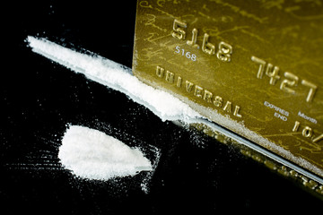 snorting and sniffing cocaine lines on mirror with rolled banknote gold credit card drugs use and...