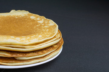 stack of pancakes on a white plate black background, selective focus With copy space