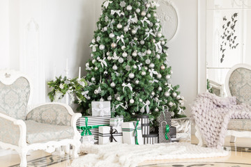 classic apartments with a white fireplace, decorated tree, bright sofa, large windows. Christmas morning.