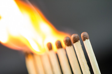 burning matches on a dark background crisis intervention concept, close up,  selective focus , blurred neutral background