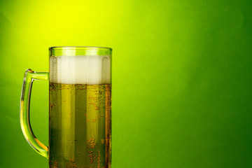 glass of beer foam bubbles close up, copy space, selective focus , blurred neutral  green background