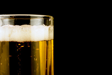 glass of beer foam bubbles close up, copy space, selective focus , black  background
