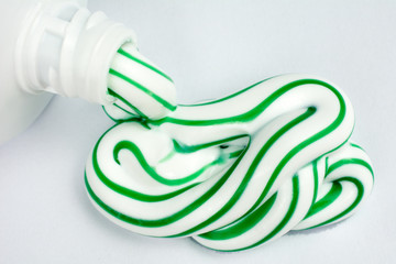 Green and white toothpaste squeezed out of a tube dental hygiene concept, close up, selective...