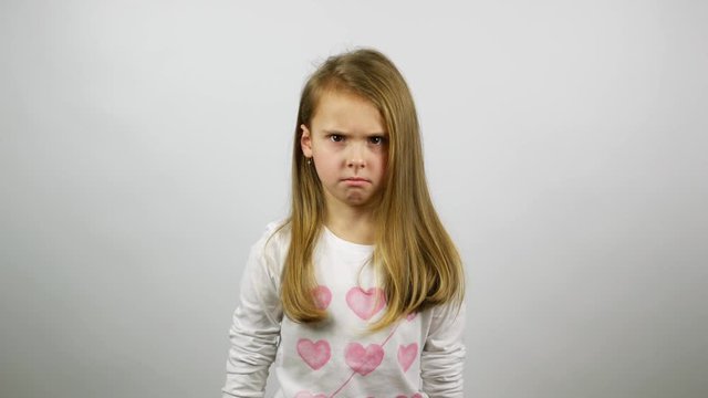 The young girl looking angry and begins to cry. A frustrated child crying looking straight 