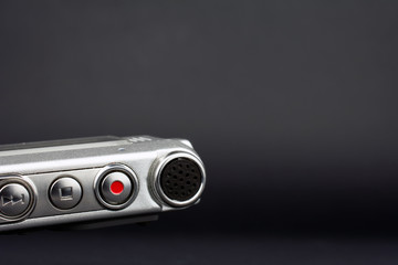 Fototapeta premium dictaphone closeup of a red record button selective focus dark blurred background journalism concept copy space
