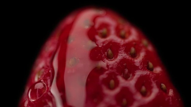macro of strawberry texture and a trandparent drop on it moving slowly
