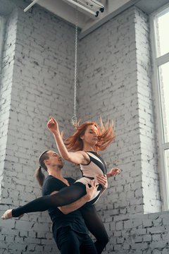 The two young modern ballet dancers in black suits over urban background.