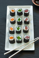 A selection of sushi rolls with salmon, tuna and cucubmer with soy sauce dip.