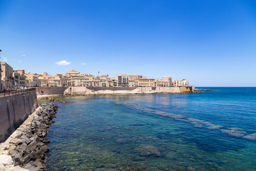 Fototapeta na wymiar Syracuse, Italy. A picturesque old quay on the island of Ortygia in sunny weather