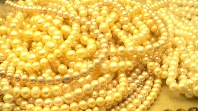4K view of a heaps of pearl necklaces in the shop window of a jewelry store. 