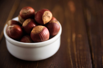 Obraz premium Hazelnuts in white ceramic bowl